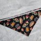 Bandana shown with measuring tape to show medium size is 21", print is black with apples and apple treats like pies and cider.