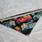 Bandana shown with measuring tape to show size is 17.5", print has trucks with pumpkins in them on black background.