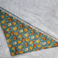 Bandana shown with measuring tape to show large size is 25.5", print is pumpkins on dusty blue background.