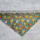 Bandana shown with measuring tape to show medium size is 21", print is pumpkins on dusty blue background.