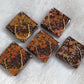 Five square epoxy resin pieces with fall trees scene made of jewelry wire and leaf shaped glitter.