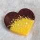 Heart shaped epoxy resin piece made with dark red and bright yellow glitter.