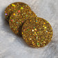 Three round epoxy resin pieces made with holographic gold glitter.
