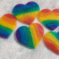 Five heart shaped epoxy resin pieces, each with rainbow stripes in shimmering mica pigments.